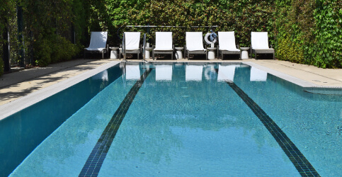 outdoor pool with white lounge chairs
