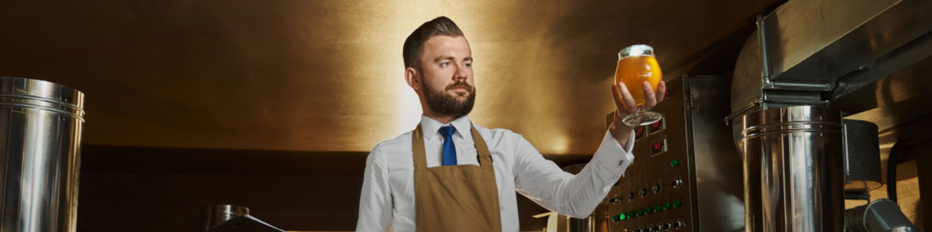 man holding up glass full of beer