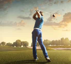 a man in the middle of hitting his ball and watching where it goes