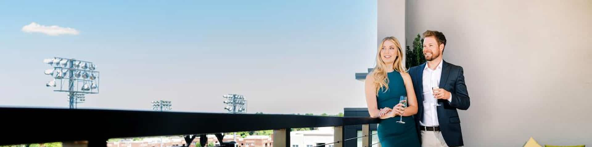 a couple out on balcony looking over baseball stadium