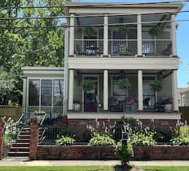 two story green house with front porches