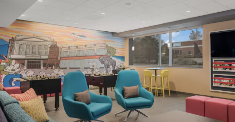 lounge area with foosball tables and a mural