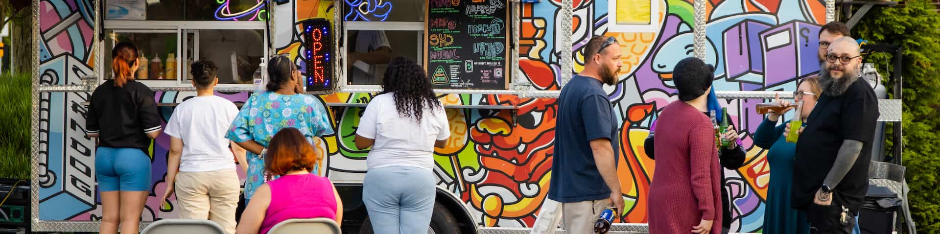 people lined up in front of food truck placing orders