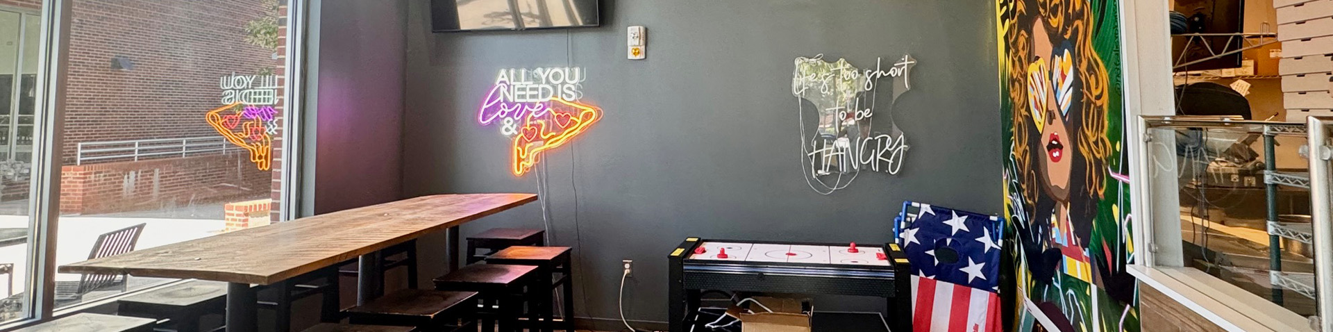 inside the pizza shop with art work and flag shown