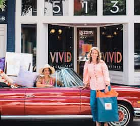 two ladies loading products into their car in front of the shop