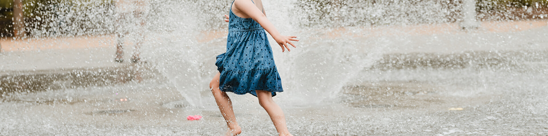 girl playing in fountain