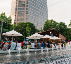 fountain and people watching a performance in the park