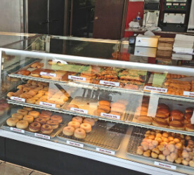display shelves of donuts and pastries