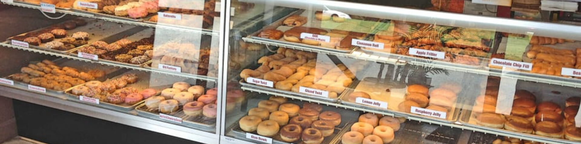 display shelves full of donuts and pastries