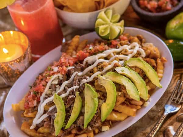 Mexican dish with avocado and garnish with candle in background