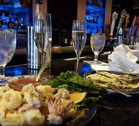 table with food set and wine glasses in background