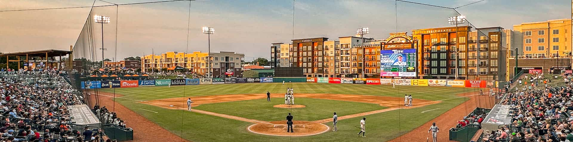 picture of the whole stadium with downtown Greensboro buildings in the background