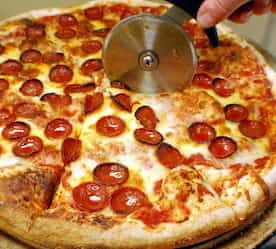 cutting a pizza with a pizza cutter