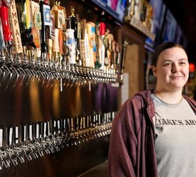 bar tender in front of beer taps