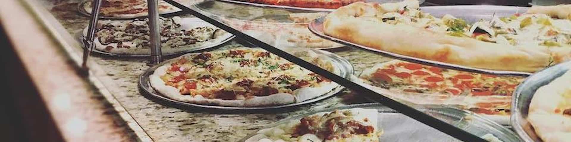 two rows of pizza options close to where customers place order