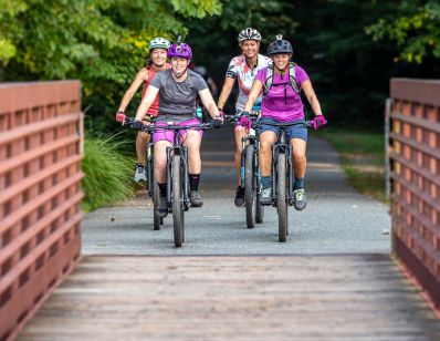 a group of girls biking over bridge